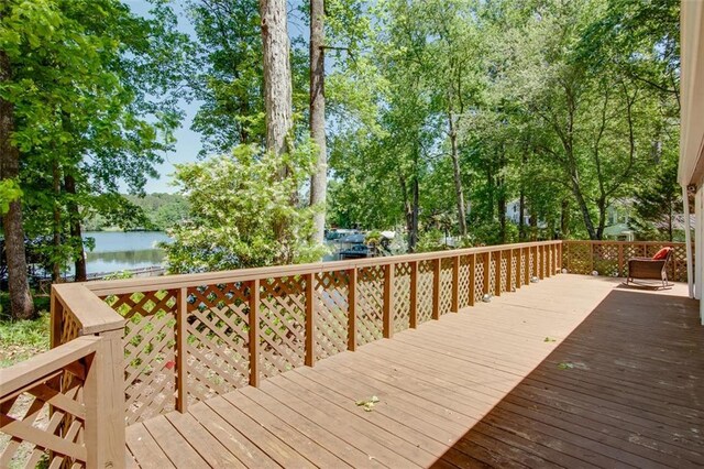 wooden deck featuring a water view and view of wooded area