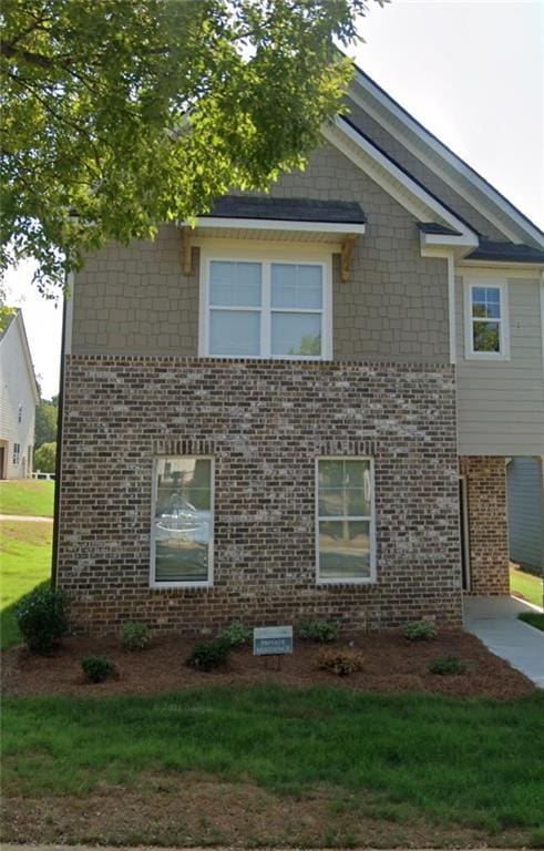 view of side of home with a yard and brick siding