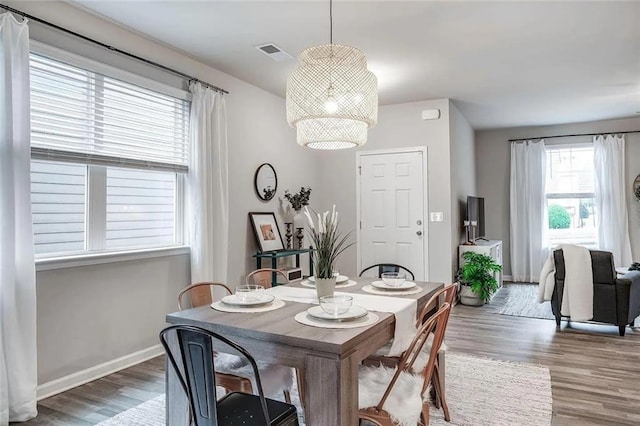 dining area with visible vents, baseboards, and wood finished floors