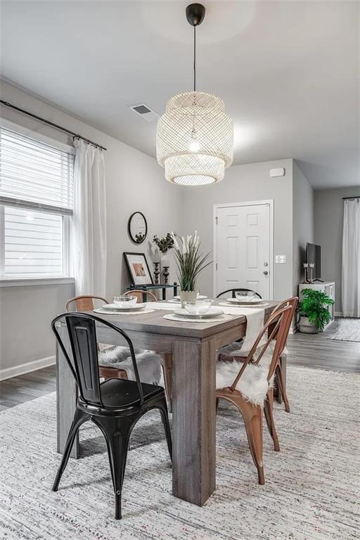 dining room with wood finished floors, visible vents, and baseboards