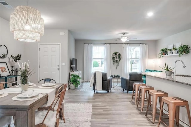 dining space featuring light wood-style floors, visible vents, and ceiling fan