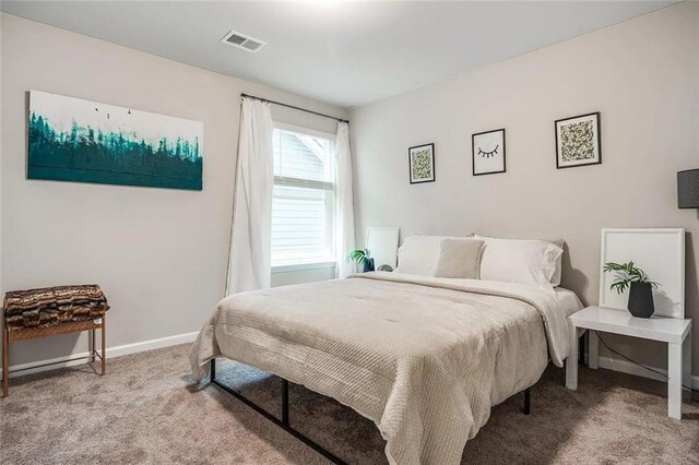 bedroom with carpet, visible vents, and baseboards