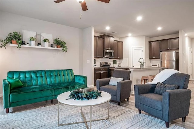 living room featuring recessed lighting, light wood finished floors, and ceiling fan