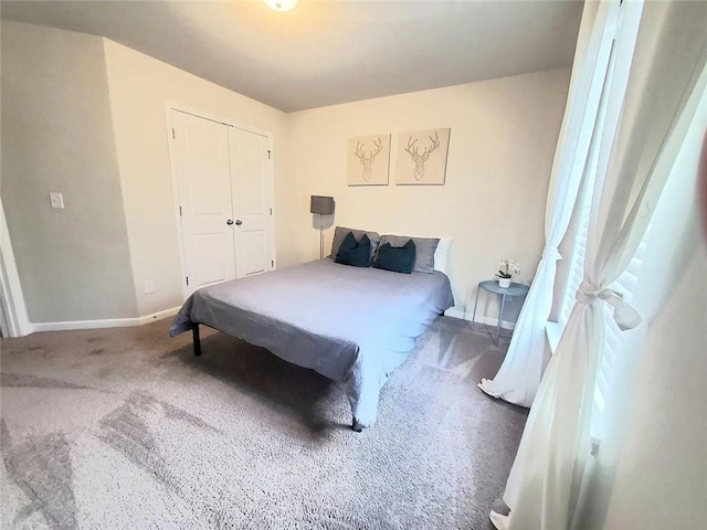 carpeted bedroom with a closet and baseboards