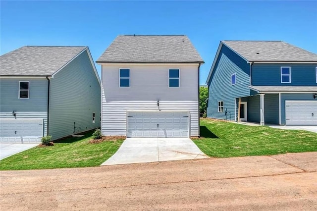 view of front of house with a front lawn, an attached garage, and driveway