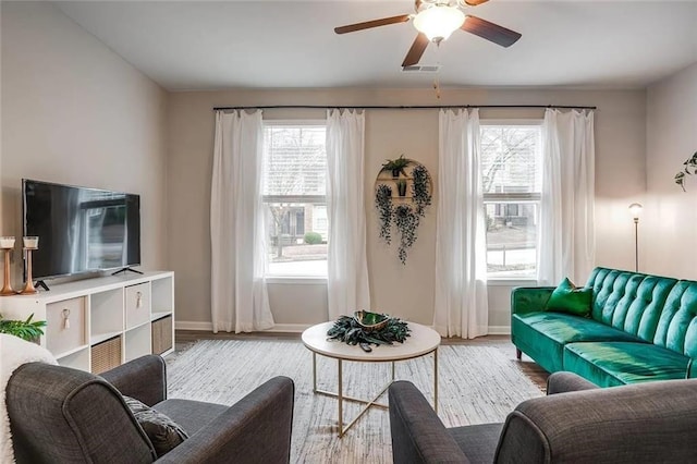 living room with visible vents, a ceiling fan, baseboards, and wood finished floors