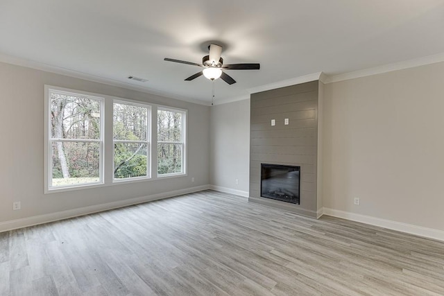 unfurnished living room with ceiling fan, light hardwood / wood-style floors, ornamental molding, and a fireplace