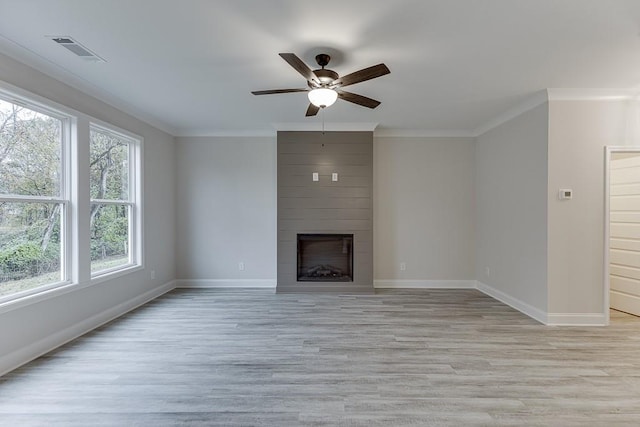 unfurnished living room with ceiling fan, ornamental molding, a fireplace, and light hardwood / wood-style flooring