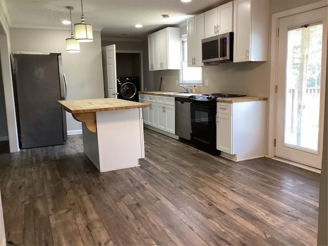 kitchen with a center island, wood counters, stainless steel appliances, white cabinetry, and washer / clothes dryer