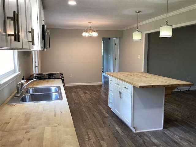 kitchen featuring dark hardwood / wood-style flooring, white cabinetry, sink, butcher block countertops, and a kitchen island