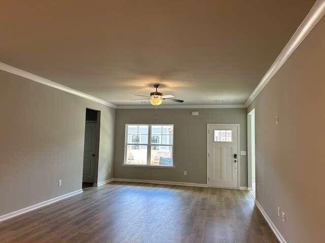 empty room with ceiling fan, dark hardwood / wood-style floors, and ornamental molding