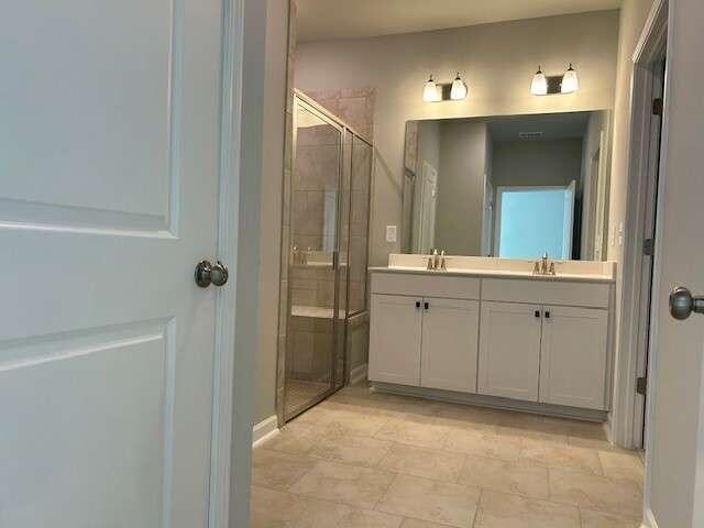 bathroom with vanity and a shower with door