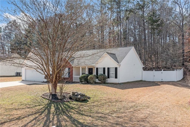 ranch-style home featuring a porch, driveway, a front lawn, and fence