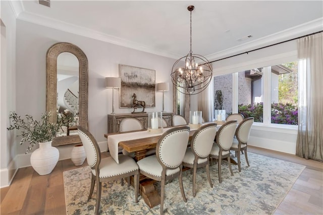 dining room with a chandelier, stairs, baseboards, wood finished floors, and crown molding