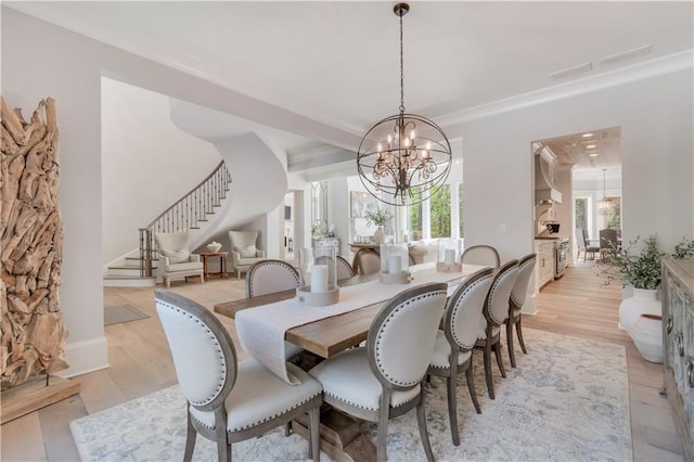 dining space featuring stairs, a chandelier, and light wood-style floors