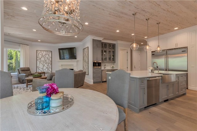 dining space with light wood-type flooring, recessed lighting, wooden ceiling, a fireplace, and crown molding