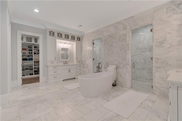 bathroom featuring ornamental molding, a marble finish shower, vanity, a spacious closet, and a freestanding bath