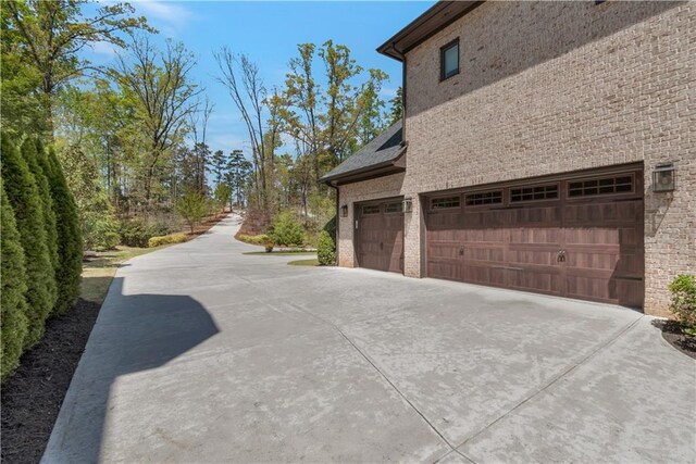view of side of property with concrete driveway and an attached garage