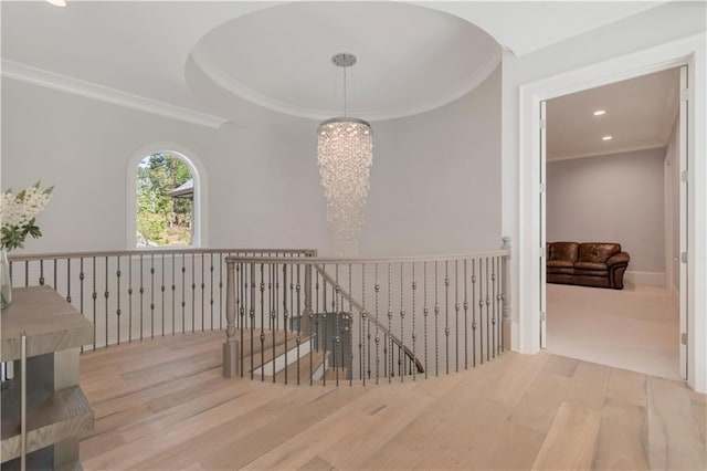 stairs featuring a chandelier, wood finished floors, crown molding, and recessed lighting