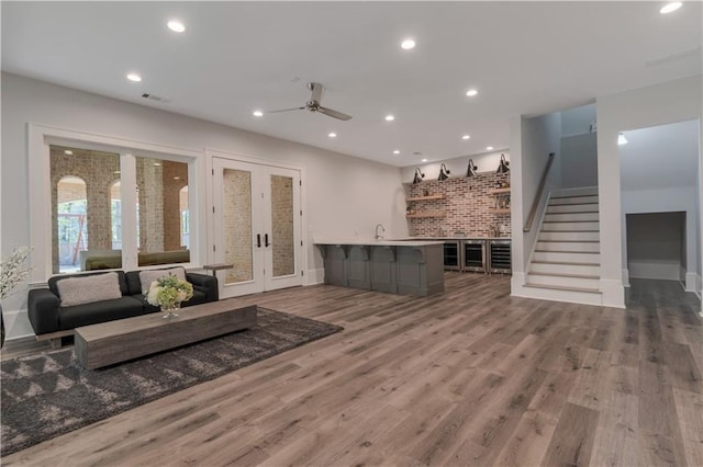 living area with stairway, a ceiling fan, wood finished floors, and recessed lighting