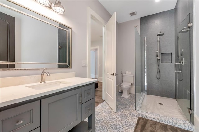 full bathroom with a shower stall, vanity, toilet, and tile patterned floors