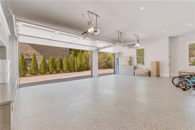 garage featuring a garage door opener, recessed lighting, and baseboards
