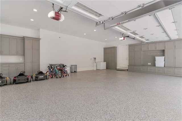 garage with a garage door opener and recessed lighting