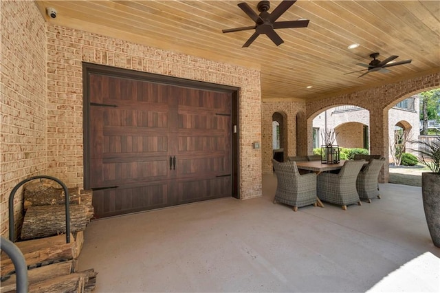 view of patio / terrace with ceiling fan, a garage, and outdoor dining area