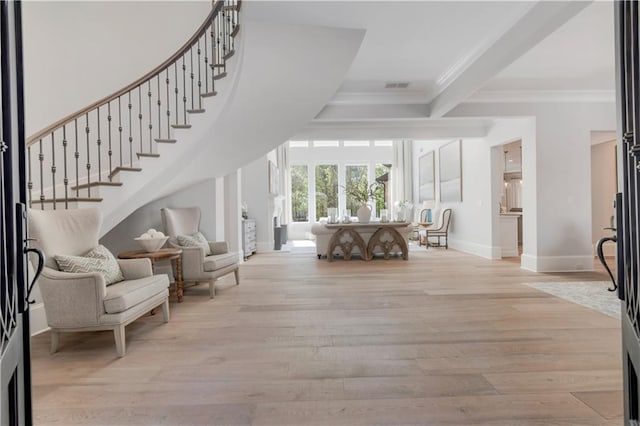 foyer with ornamental molding, baseboards, wood finished floors, and stairway