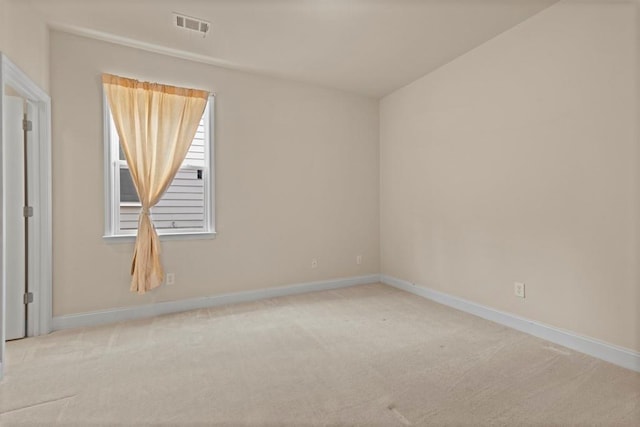 carpeted empty room featuring visible vents and baseboards