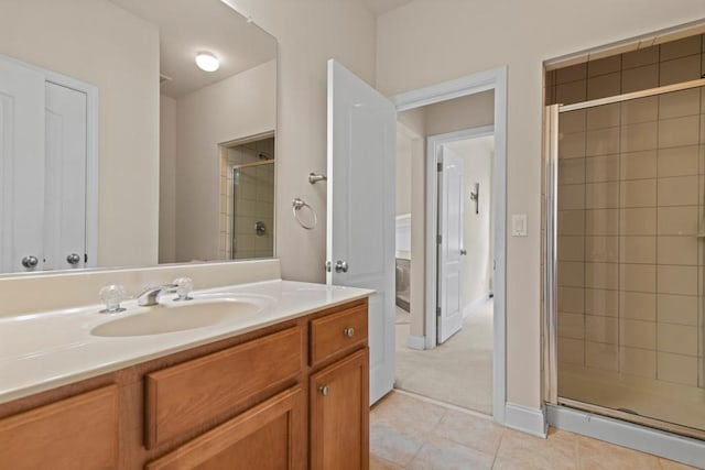 bathroom with tile patterned flooring, a shower stall, and vanity