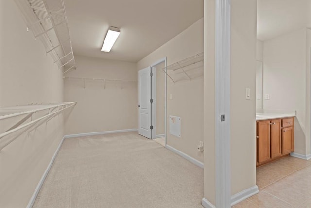 walk in closet featuring light colored carpet