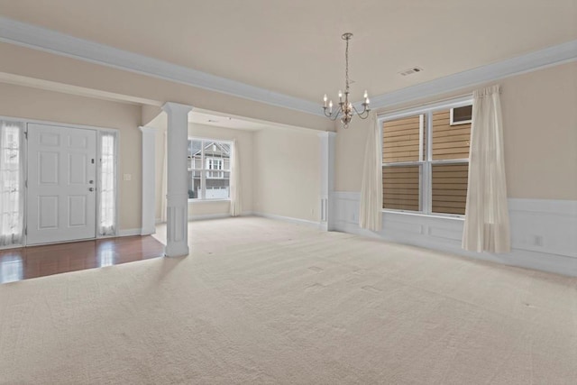 foyer entrance featuring ornamental molding, carpet, and a wainscoted wall