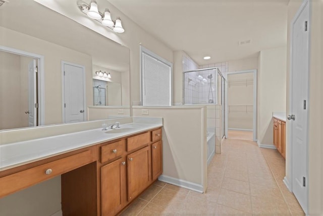 full bath featuring a shower stall, a walk in closet, tile patterned flooring, and vanity