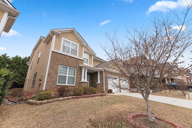 craftsman-style home with driveway, brick siding, an attached garage, and a front yard