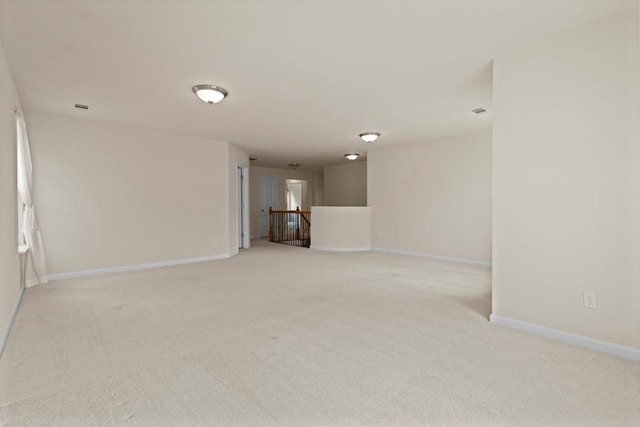 unfurnished living room with light carpet, visible vents, and baseboards