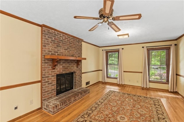 3802 SW Knights Bridge Rd SW, Lilburn, GA 30047 - unfurnished living room featuring wood finished floors, a fireplace, ceiling fan, ornamental molding, and a textured ceiling