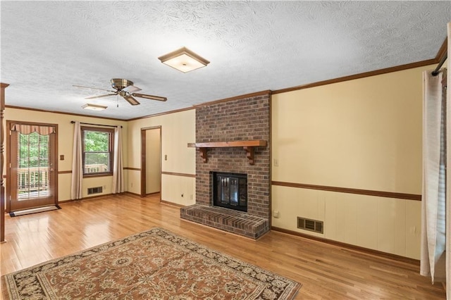 3802 SW Knights Bridge Rd SW, Lilburn, GA 30047 - unfurnished living room featuring wood finished floors, a fireplace, a ceiling fan, ornamental molding, and a textured ceiling