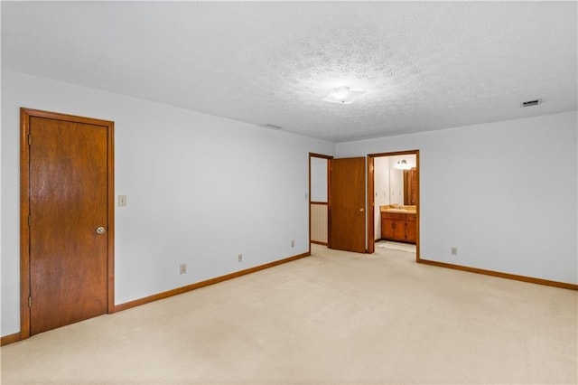 3802 SW Knights Bridge Rd SW, Lilburn, GA 30047 - unfurnished bedroom with light carpet, baseboards, a textured ceiling, and ensuite bathroom