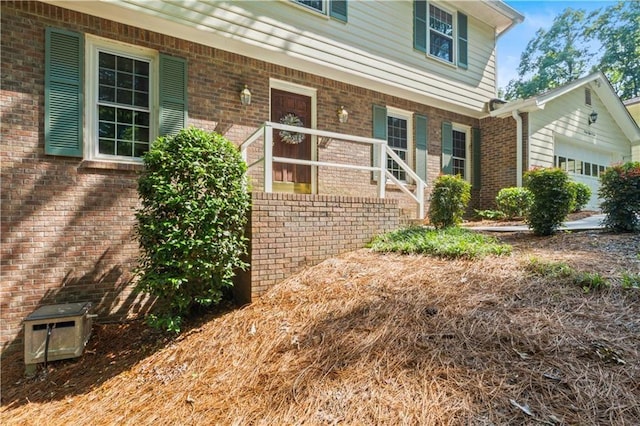 3802 SW Knights Bridge Rd SW, Lilburn, GA 30047 - view of exterior entry featuring a porch, brick siding, and a garage