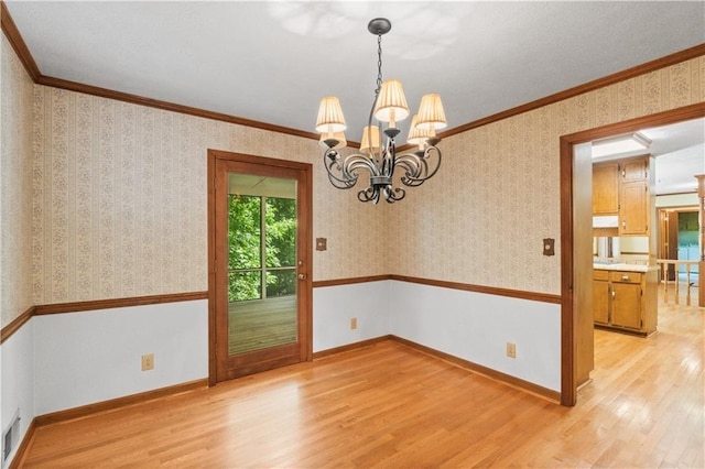 3802 SW Knights Bridge Rd SW, Lilburn, GA 30047 - spare room with light wood-type flooring, a chandelier, wallpapered walls, crown molding, and baseboards