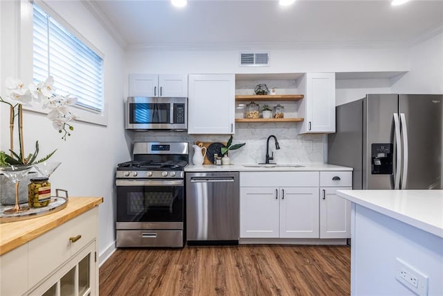 115 Biscayne Dr NW Unit F10, Atlanta, GA 30309 - kitchen featuring appliances with stainless steel finishes, a sink, decorative backsplash, dark wood finished floors, and crown molding