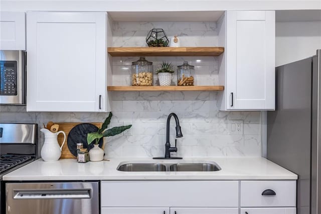 115 Biscayne Dr NW Unit F10, Atlanta, GA 30309 - kitchen with appliances with stainless steel finishes, a sink, white cabinetry, light countertops, and tasteful backsplash