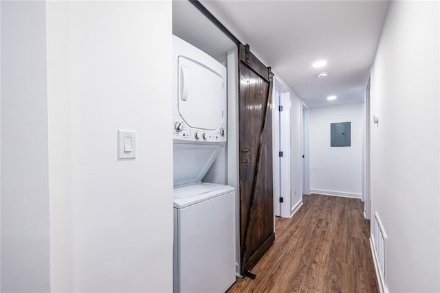 115 Biscayne Dr NW Unit F10, Atlanta, GA 30309 - laundry area with stacked washer / drying machine, electric panel, a barn door, dark wood finished floors, and baseboards