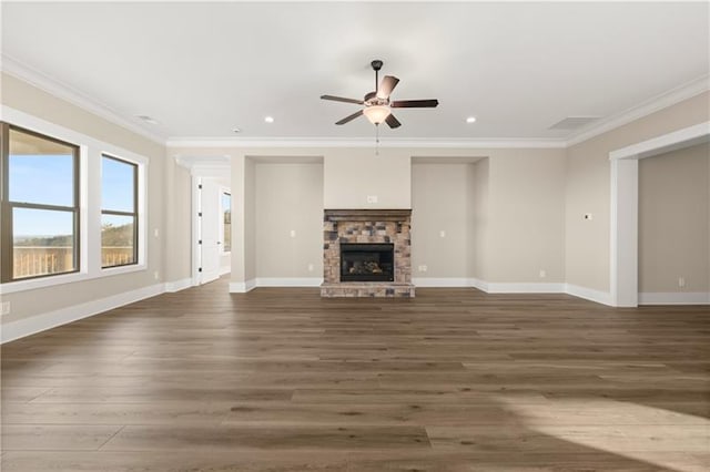 unfurnished living room with baseboards, ornamental molding, wood finished floors, and a stone fireplace