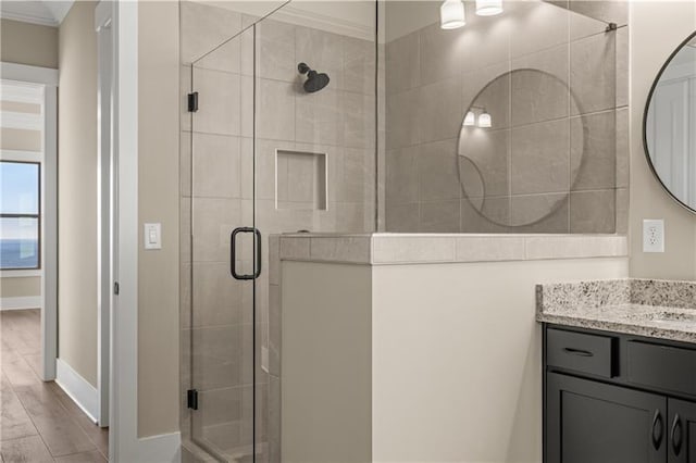 full bath with a shower stall, crown molding, wood finished floors, and vanity