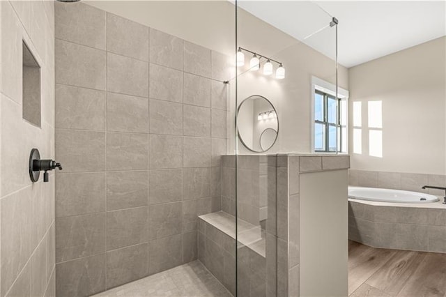 full bath featuring a garden tub, wood finished floors, and a tile shower