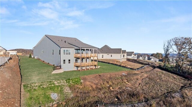 rear view of property with a deck and a lawn