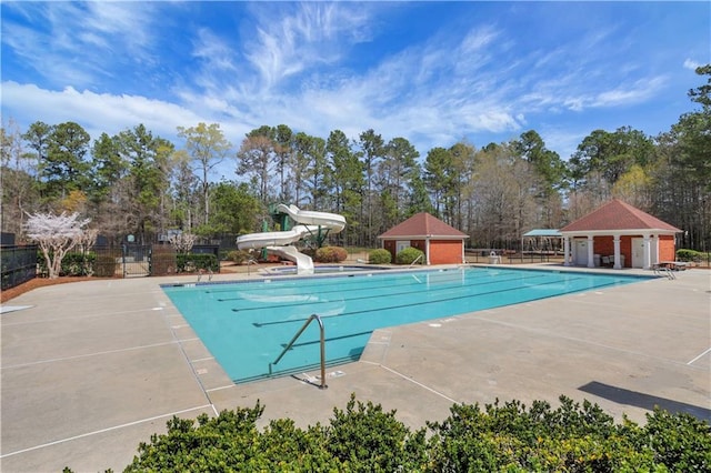 3485 Walnut Rdg, Atlanta, GA 30349 - community pool with fence, a water slide, a patio area, and view of scattered trees