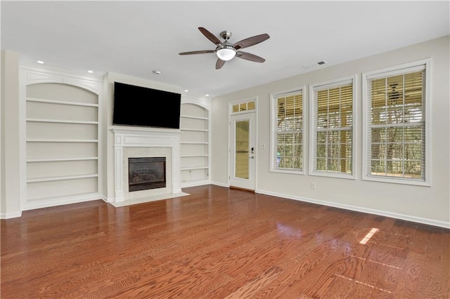 3485 Walnut Rdg, Atlanta, GA 30349 - unfurnished living room featuring a ceiling fan, baseboards, a fireplace with flush hearth, wood finished floors, and built in features